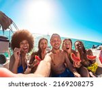 Small photo of Happy multiracial friends eating watermelon while doing sea tour with sailing boat - Summer and vacation concept - Main focus on center man face