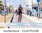 Small photo of woman riding a bike on bikeway in la Avenida del Mar, La Serena