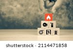 Small photo of Hand choose wooden block stack with fire icon with door exit with fire extinguisher and emergency prevent protection symbol for safety.