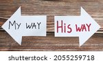 Small photo of God Jesus Christ way of life. Choose the path to eternal life. Follow God. The biblical concept of godly wisdom, guidance, leading, and Christian growth. Handwritten words on paper arrows. A closeup.