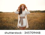 Fashion portrait of beautiful young pretty girl with hippie outfit holding hat outdoors at sunset. Soft warm vintage color tone. Boho lifestyle. Bohemian Style. Horizontal with blank space for text