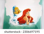 Small photo of Disney princess. Ariel the Little Mermaid and Flounder. Illustrations in a magazine. Characters from classic children's stories.