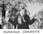 Small photo of Happy small girl in autumn park. Small girl did it in mistake. Oops. Even the wisest of us can make a mistake. The first touches of autumn. Enjoy happy childhood.
