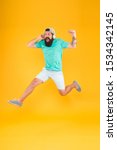 Small photo of Energy of rhythm. Music fan. Man listen music wireless headphones in motion. Bearded guy enjoy music. Impetuous movement. Hipster dancing jumping headphones gadget. Inspiring song. Music library.