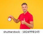 Small photo of He is always punctual. Punctual man hold alarm clock showing thumbs up. Happy being on time. Precise time. Punctuality and accurate timekeeping. Regular as clockwork.