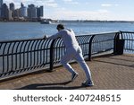 Small photo of Sportsman stretching his muscles after running. Sportsman stretch to improve flexibility. Sport man stretching and warm up for workout. Stretching routine of sportsman outdoor in NY. Calf stretch