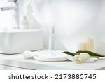 Small photo of Cosmetics product and cotton towels, cottons pad with green plant on white table inside a bathroom background ceramic.