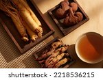 A wooden trays with bowls of medication, ginseng, red ginseng and reishi mushrooms. Traditional medicine.