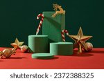 Christmas decoration concept with golden accessory and empty podiums displayed on green background. Scene for advertising with blank space for presentation products. Front view
