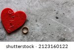 Small photo of broken heart sewn with thread and wedding ring divorce concept with space for text on gray background