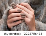 Small photo of Female hands with brown nail design. Mate brown nail polish manicure. Female model hands with perfect brown manicure on beige fluffy fabric.