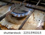 Small photo of The gas burner on the dirty stove is on. Fire from a gas burner. blue flame from the gas stove comcorder. Dirty stove.