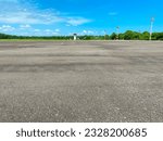 Small photo of empty or quiet runway airport with lots of trees at noon against bright blue sky with clouds