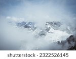 Dramatic mountain scenery in the High Tatras mountains Slovakia, with snow-capped summits and swirling clouds. Taken from the summit of Lomnický štít.