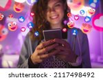 Happy young woman using her phone to interact with social media, getting followers, likes, emoji feedback