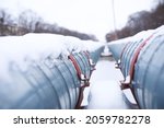 Winter landscape with the snow-covered gas pipeline and trees in hoarfrost. Gas pipe transite snow winter.