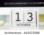 Cube shape calendar for OCTOBER 13 and computer keyboard on table. 