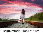 a little girl run away home on the railway, walking lonely ahead without destination