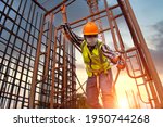 Small photo of Construction workers hook up safety belts At construction working buildingWorking at height equipment Construction worker wearing safety harness and safety line working on construction at high place.