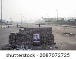 Small photo of Cairo, Egypt - July 03 2013: Stone barricade that demonstrators set up on Enver Sadat street. Above the barricade is a photograph of former President Morsi.