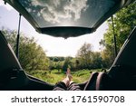 man sitting in car trunk looking at forest. beautiful landscape view. road trip concept
