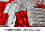 Small photo of A stack of pill blisters. White and red medicine blisters. Unpacked drugs close up. Complex therapy, polypharmacy, pharmacotherapy. Drug policy. Pharmaceutical industry concept.