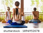 Small photo of Back view of young people group practicing yoga with instructor. Stretching class at summer retreat camp to keep fit and health. Woman fitness, recreational sport activity on family holiday.