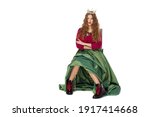 Small photo of Fashion photo of a beautiful elegant young teenager girl with long curly hair in the crown and a pretty long green skirl isolated on white background.