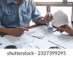 Small photo of Architects interior designer hands working with Blue prints and documents for a home renovation for house design.