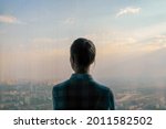Success, opportunity, sightseeing, discover, dramatic and future concept. Back view of pensive woman silhouette looking at cityscape through window of skyscraper. Summer time, cloudy, daylight