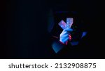 Prescription drug. Pharmaceutical research. Red blue neon light doctor hand holding pills in blister packs in black breakthrough hole torn wall isolated on dark copy space banner.