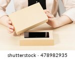 Woman opening box with new smartphone, close-up. Female customer lifting lid from package with her order. Delivery service. online shopping, parcel opening , gift concept