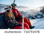 Close-up of couple man and woman snowboarders on a cable ski lift in the morning in Bukovel enjoying a beautiful view of the Carpathian Mountains copyspace recreation active sport seasonal concept