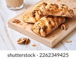 Pecan and walnut plait pastry filled with maple sirup on wooden board