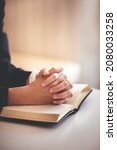 Small photo of focus on woman's hand While praying for Christianity with blurry body background, praying with her hands with scriptures.