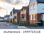 Houses in England with typical red bricks at sunset - Main street in a new estate with typical British houses on the side - Real estate and buildings concepts in UK