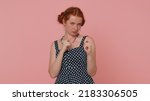 Small photo of Greedy avaricious redhead young woman showing fig negative gesture, you dont get it anyway. Rapacious, avaricious, acquisitive. Body language. Refusal fig sign. Ginger girl indoor on pink background