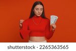 Small photo of Upset pretty woman showing red arrow pointing down, concept of downgrade, unsuccessful business, fall of stock market money dollar exchange rate bankruptcy fail. Young adult girl on red background