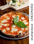 Small photo of Traditional New York City style margarita Pizza, with a thin homemade crispy crust, fresh tomato garlic marinara sauce topped with buffalo mozzarella cheese and fresh basil leaves.