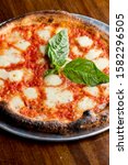Small photo of Traditional New York City style margarita Pizza, with a thin homemade crispy crust, fresh tomato garlic marinara sauce topped with buffalo mozzarella cheese and fresh basil leaves.