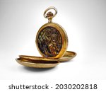 Antique gold pocket watch with water damage and rust on dial face and movement.