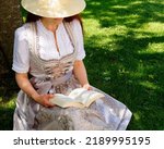 A Woman Wearing A Hat And A...