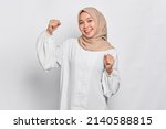 Excited Asian Muslim woman celebrating victory isolated over white background
