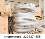 Packed metal hoses for transporting substances and media, wrapped in stretch film and ready for shipping.