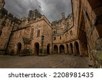 Small photo of Nice view of an inner courtyard of alnwick castle under a grey overcast and threatening sky, in england