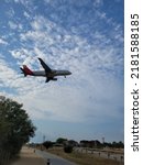 Small photo of BARCELONA, SPAIN - 23th of July 2022: Iberia airplane landing in Barcelona- El Prat Airport. Iberia is a spanish airline. Views from "El Delta del Llobregat"