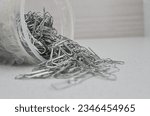 Closeup of paper clips on a light surface, ideal for office and stationery concepts and perfect for organizing and protecting documents.