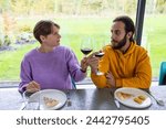 Small photo of This inviting photograph captures two friends sharing a moment over wine, exchanging meaningful glances that suggest deep conversation and understanding. The casual dining experience with pizza slices