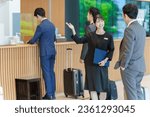 Small photo of female asian concierge explaining to customer at hotel reception
