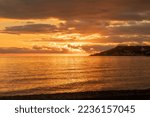 a fantastic red sunset over the Ligurian Sea in the province of Imperia. Italy. Sky and sea are mirrored. December 2022